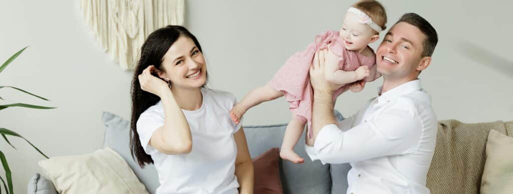 Parents posing with their baby. If they work and have disability and paid family leave insurance, the parents can feel safe knowing they're protected.